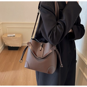 Detail shot of the lychee texture dark brown leather bucket bag with elegant stitching