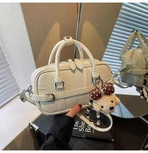 Détail du sac polochon en simili cuir blanc crème avec charmant pendentif ours
