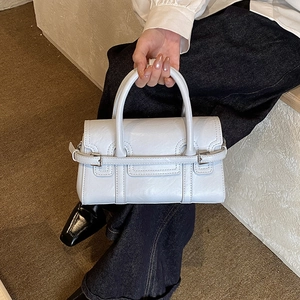 Detail shot of the structured light blue handbag showing fine leather texture and stitching