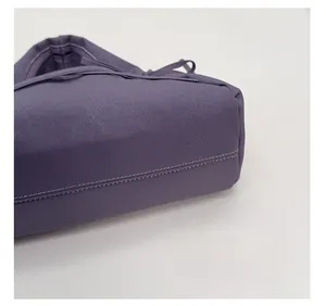 Dettaglio della borsa a pieghe viola con cuciture a doppia fila e pelle martellata