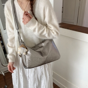 Détail du sac hobo argenté métallisé froissé avec breloque en peluche et fermeture éclair