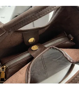 Détails de l'intérieur du sac en cuir marron avec fermoirs magnétiques dorés et zip
