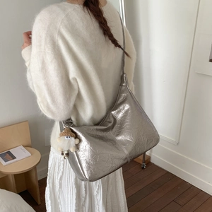 Détail du grand sac hobo argenté métallisé avec texture plissée et breloque peluche