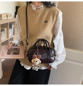 Détail du sac Boston en cuir verni marron foncé avec charmant petit chien en peluche