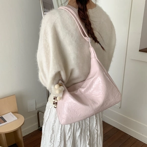 Détail du sac hobo rose clair en cuir verni plissé avec accessoire pompon en fourrure