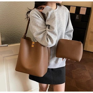 Deep brown lychee pattern leather bucket bag set shown on a model in a warm interior