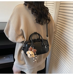 Mannequin portant un sac Boston noir avec un pendentif ours mignon pour le style