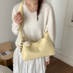 Détail du sac à bandoulière en PU jaune clair avec breloque ours et sangle perlée sur modèle