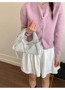Dettaglio del fiocco su una borsa a mano dumpling elegante con design a contrasto