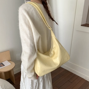 Détail du sac hobo jaune clair avec texture plissée et finition en cuir synthétique brillant
