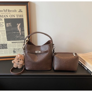 Detail view of brown vintage bucket bag set with inner pouch and cute plush puppy charm