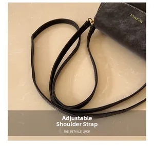 Détail de la bandoulière réglable et de la texture mate du sac bandoulière gris foncé