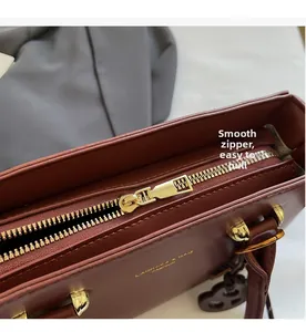 Detailed macro view of high-quality smooth golden zipper on stylish brown PU leather handbag