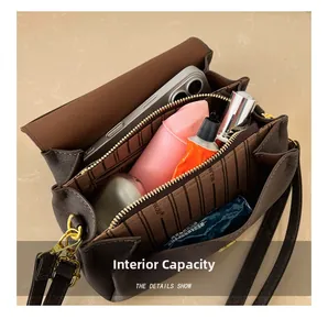 Vue intérieure d'un petit sac carré montrant plusieurs compartiments et ferrures dorées