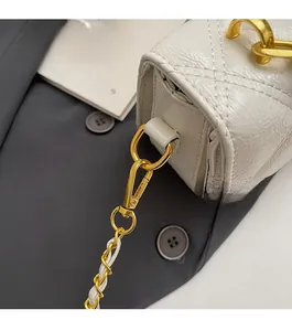 Detail of white quilted leather texture with premium gold chain and metallic hook