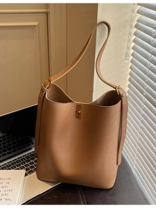 Caramel lychee grain leather bucket bag with gold twist lock for minimalist office style