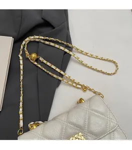 Close-up of quilted white leather bag featuring a gold chain strap with adjustable metal ball
