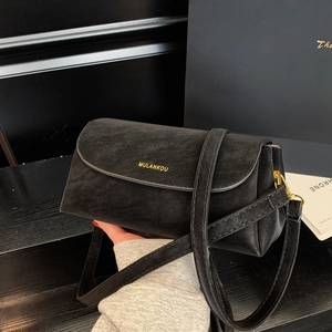 Gros plan d'un sac carré en cuir noir rétro avec d'élégantes boucles en métal doré