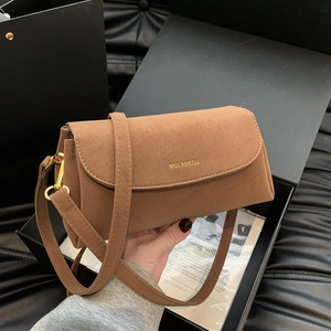 Vue détaillée du sac bandoulière en daim marron avec logo doré sur coffret cadeau