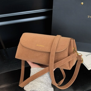 Vue détaillée de la texture du cuir marron mat et du logo doré MULANKOU sur le sac