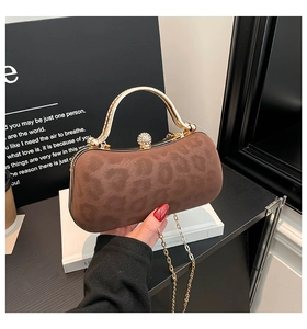 Détail du sac de soirée léopard avec poignée dorée et fermoir diamant étincelant