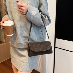 Vue détaillée du sac en cuir mat marron foncé avec crochets dorés et logo gravé