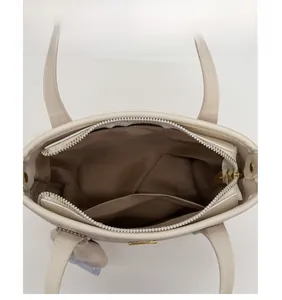 Top view showing internal capacity with zippered pocket and brown lining of the handbag