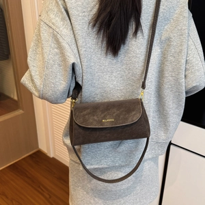 Vue détaillée du petit sac carré marron vintage avec lettres dorées et bandoulière