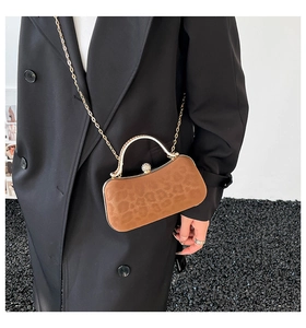 Sac de soirée léopard marron avec poignée dorée et bandoulière chaîne sur modèle