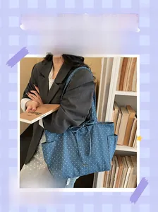 Detail showing blue denim tote bag with star prints, side pockets and drawstring bow