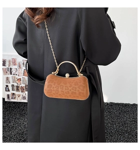 Détail du sac de soirée léopard avec poignée dorée ronde et texture pelucheuse