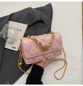 Detail of pink quilted flap bag with golden chain strap and metallic lock buckle