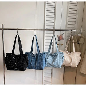 Detailed view of four canvas tote bags with star patterns and stylish bow accents