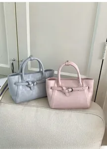 Détail de sacs à main en similicuir bleu clair et rose avec boucles et poignées décoratives