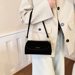 Gros plan du sac bandoulière élégant en velours noir avec logo doré et bandoulière
