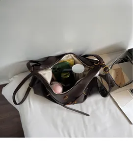 Vue de dessus du sac fourre-tout marron montrant l'intérieur spacieux avec accessoires