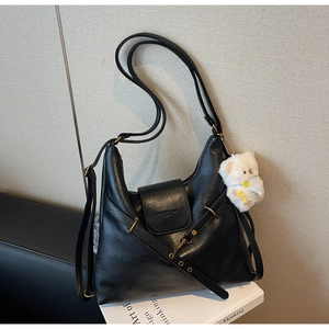 Détail du sac fourre-tout vintage en similicuir noir avec pendentif ours blanc moelleux