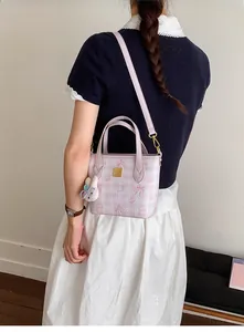 Close-up of pink bucket bag with cartoon bear prints and cute white bunny charm