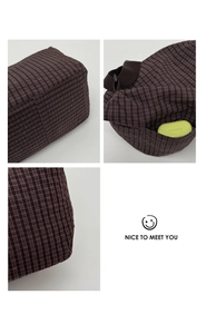 Close-up detail of a classic plaid tote bag fabric with side pocket and accessory storage