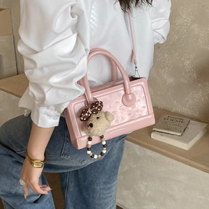 Pink patent leather square handbag with embossed cartoon detail and plush bear charm
