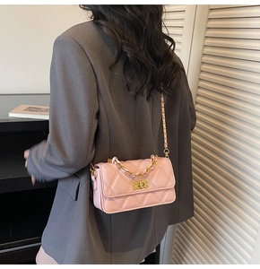 Detailed back view of model wearing pink quilted leather crossbody bag with chain