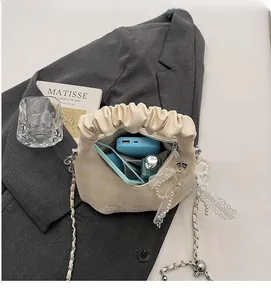 Detail of beige pleated cloud bag interior showing space for phone and essentials
