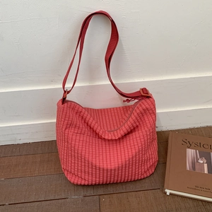 Detail of red plaid canvas hobo bag showing adjustable fabric strap and soft texture