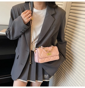 Detail showing pink quilted leather crossbody bag with golden chain and metal turn-lock