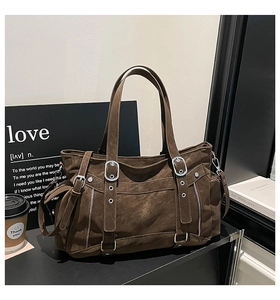 Macro detail of brown distressed leather tote featuring silver buckles and vintage texture