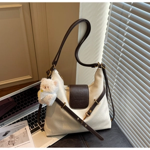 Détail d'un sac cabas en cuir grainé blanc avec bandoulière marron et rabat élégant