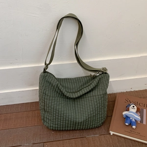 Detail view of large checkered canvas shoulder bag with adjustable strap and zipper closure