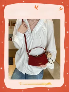 Detail of red leather dumpling bag with mushroom charm and fashion gold stamping