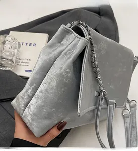 Detail of silver tote bag featuring matte mottled texture and metal chain strap
