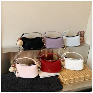 Close-up of minimalist half-moon bags in six colors with bear charms and beaded details